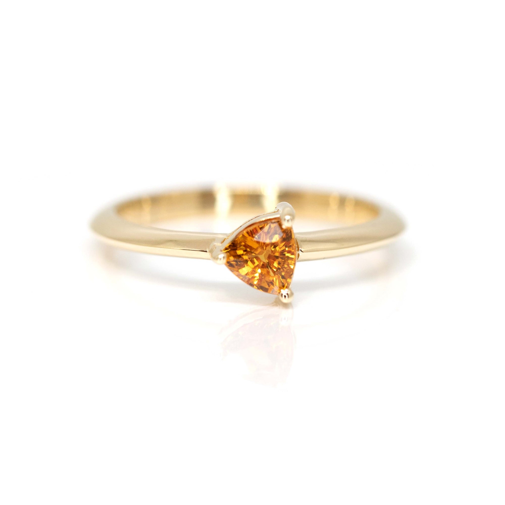 custom made colored trillion orange sapphire yellow gold bridal ring custom made in montreal by bena jewelry designer on a white background