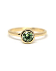 Bezel Set Demantoide Ring by Bena Jewelry, featuring a vibrant green demantoid garnet in a round cut, set in yellow gold. Photographed on a white background.