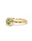 Unique green demantoid garnet ring in yellow gold by Bena Jewelry, photographed on a white background. Handmade wedding or engagement ring.