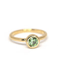 Elegant yellow gold ring featuring a green demantoid garnet by Bena Jewelry, photographed on a plain white background. Minimalist design, made in Montreal.