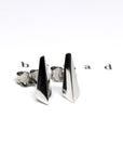 White gold Blade stud earrings by Bena Jewelry, showcased on a sleek black matte background. The sharp geometric design contrasts beautifully against the white surface, highlighting their bold and contemporary appeal. Designed in Montreal, made in Canada.