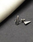 Bena Jewelry's Blade earrings in white gold, photographed on a luxurious grey slick surface. The modern unisex design combines sophistication with an edgy aesthetic. Handmade in Montreal, Canada."