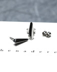 Blade stud earrings in white gold by Bena Jewelry, presented on a bright texture background. Made in Montreal, Canada.