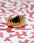 Angled shot of Pigalle Ring in Yellow Gold – A striking gold ring featuring a domed silhouette and a unique faceted pattern.