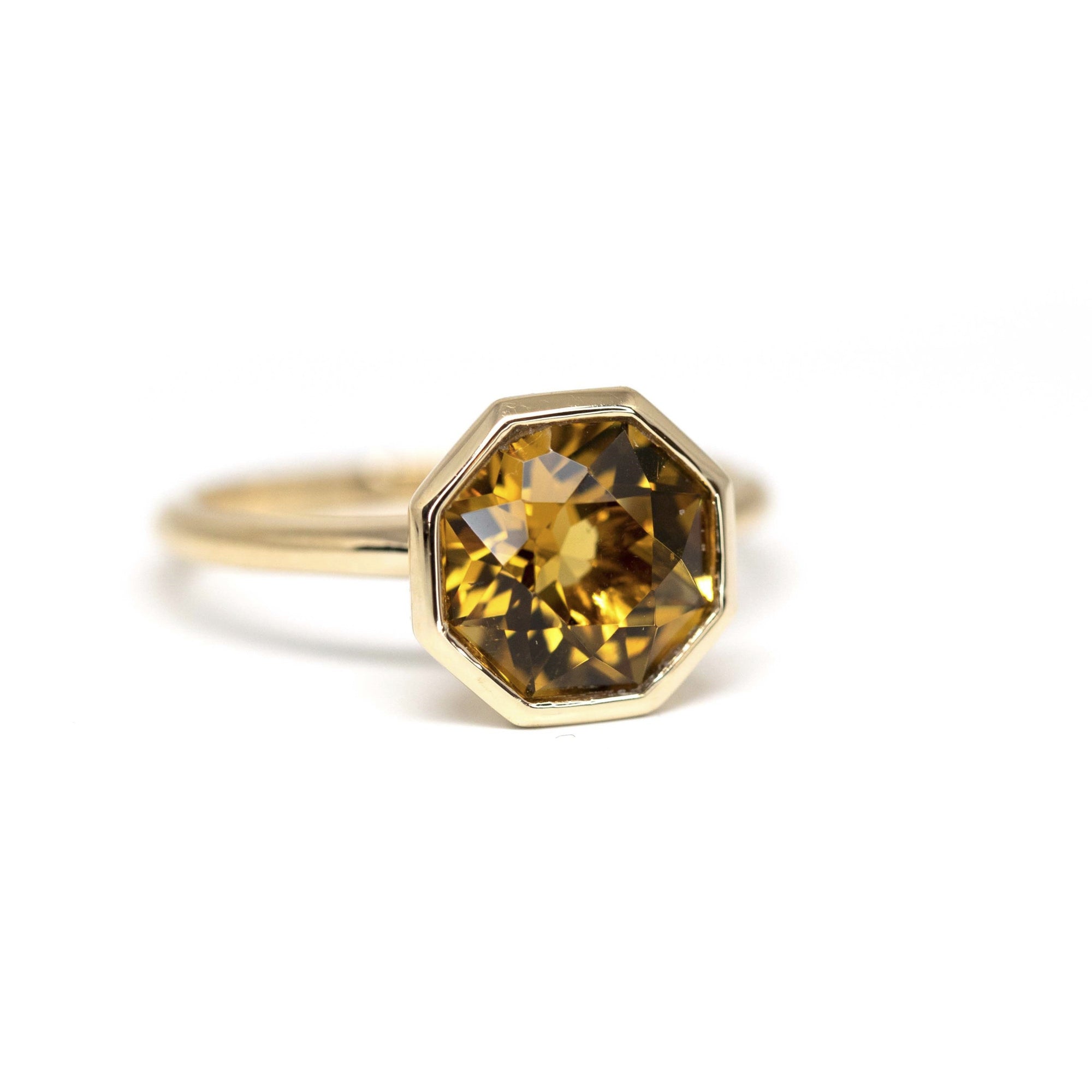 Close-up of Fireball Citrine ring – Statement ring with a fiery yellow-orange octagonal citrine, securely set in polished yellow gold. Crafted by independent designer Bena Jewelry.
