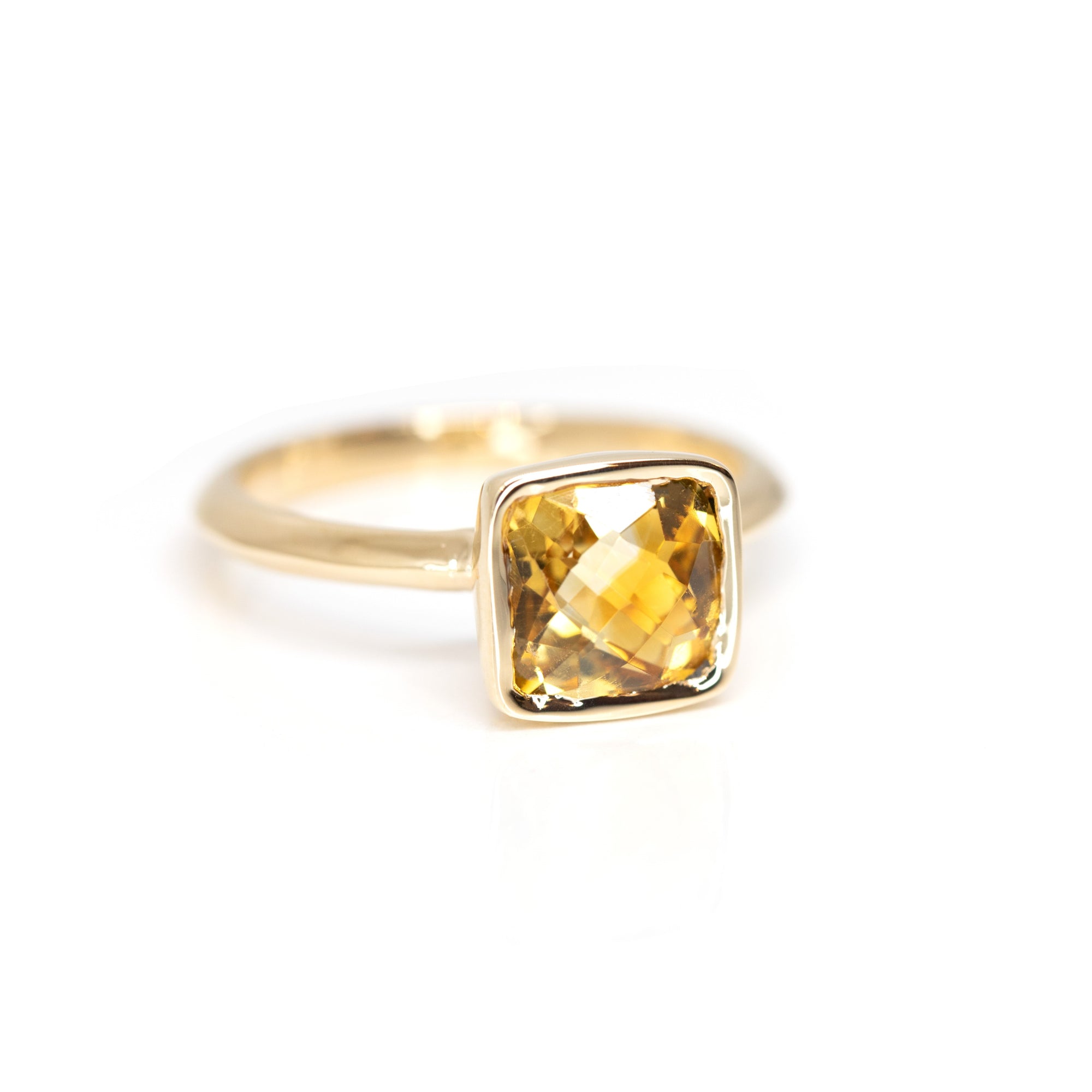 Close-up of the ring, highlighting the striking contrast between the warm yellow-orange citrine and the rich yellow gold band. By Bena Jewelry, Montreal custom jewellery designer.