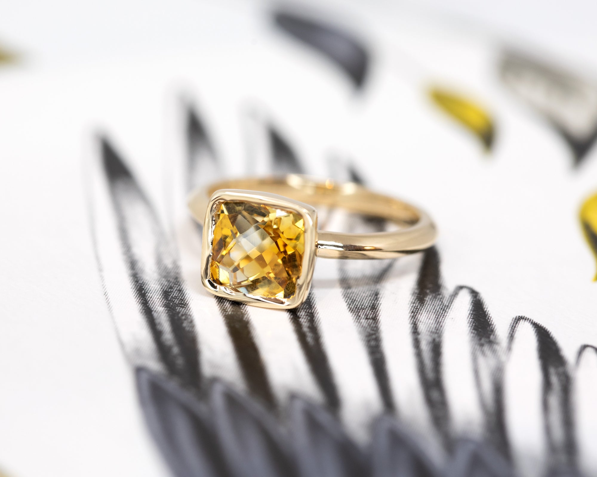 Close-up of the citrine, emphasizing the stone's natural brilliance and warm tones, set in polished yellow gold by Bena Jewelry.