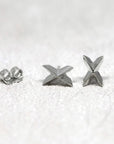 White gold Cross Gold Studs with bold geometric styling by Bena Jewelry, displayed on a light-colored background, unique unisex fine jewelry made in Canada.