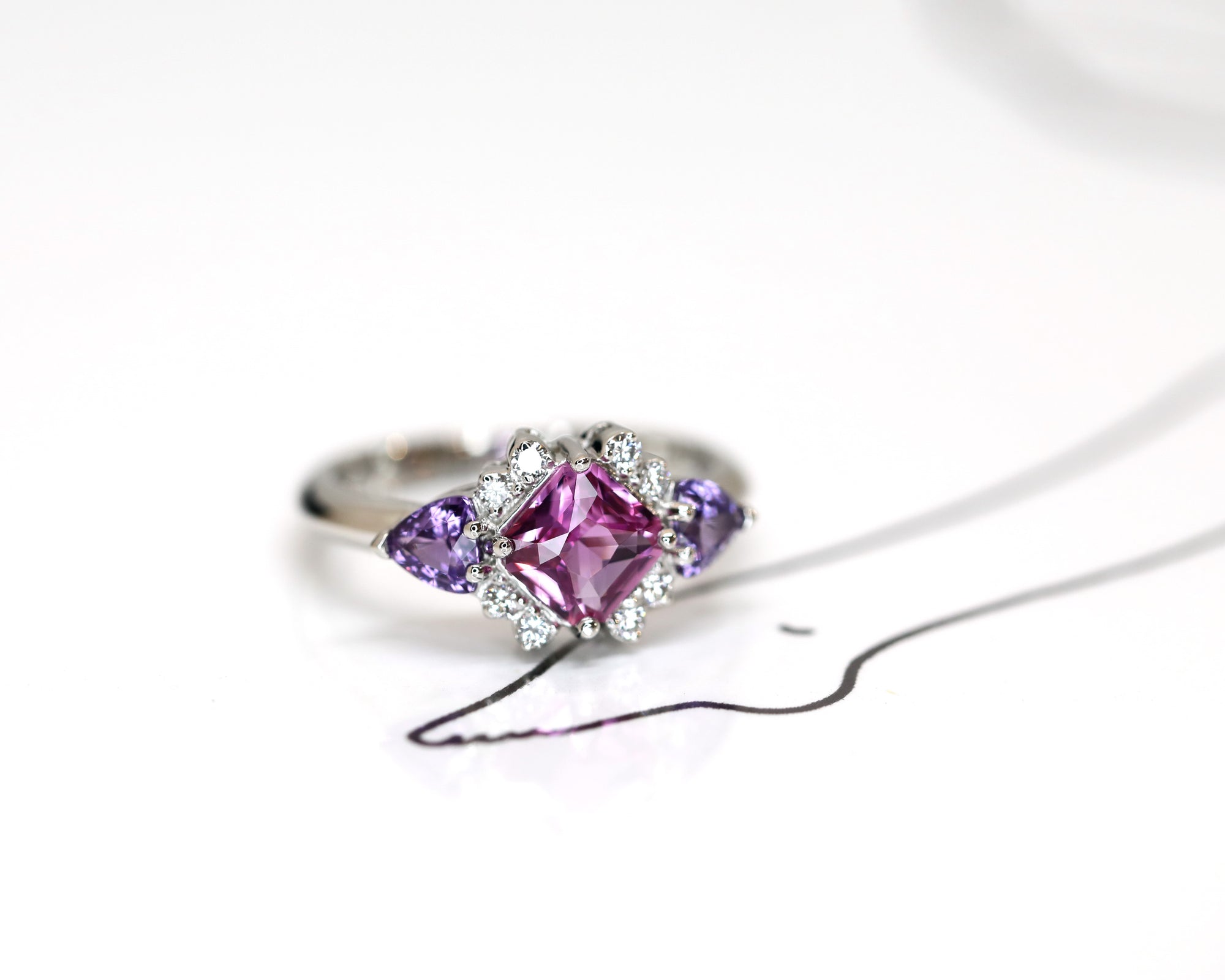 side view square pink and purple sapphire and diamond platimum ring custom made jewels in bena jewelry on white background