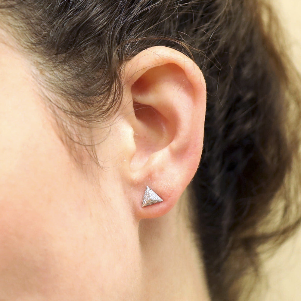Close-up of the earrings worn, emphasizing their pyramid shape, diamond brilliance, and modern design.