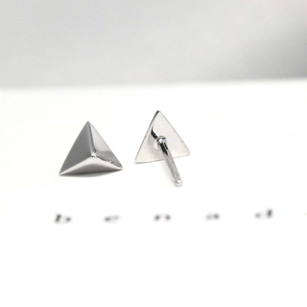 White gold pyramid-shaped earrings, Delta Gold Studs by Bena Jewelry, displayed on a plain white background, custom modern jewelry crafted in Canada.