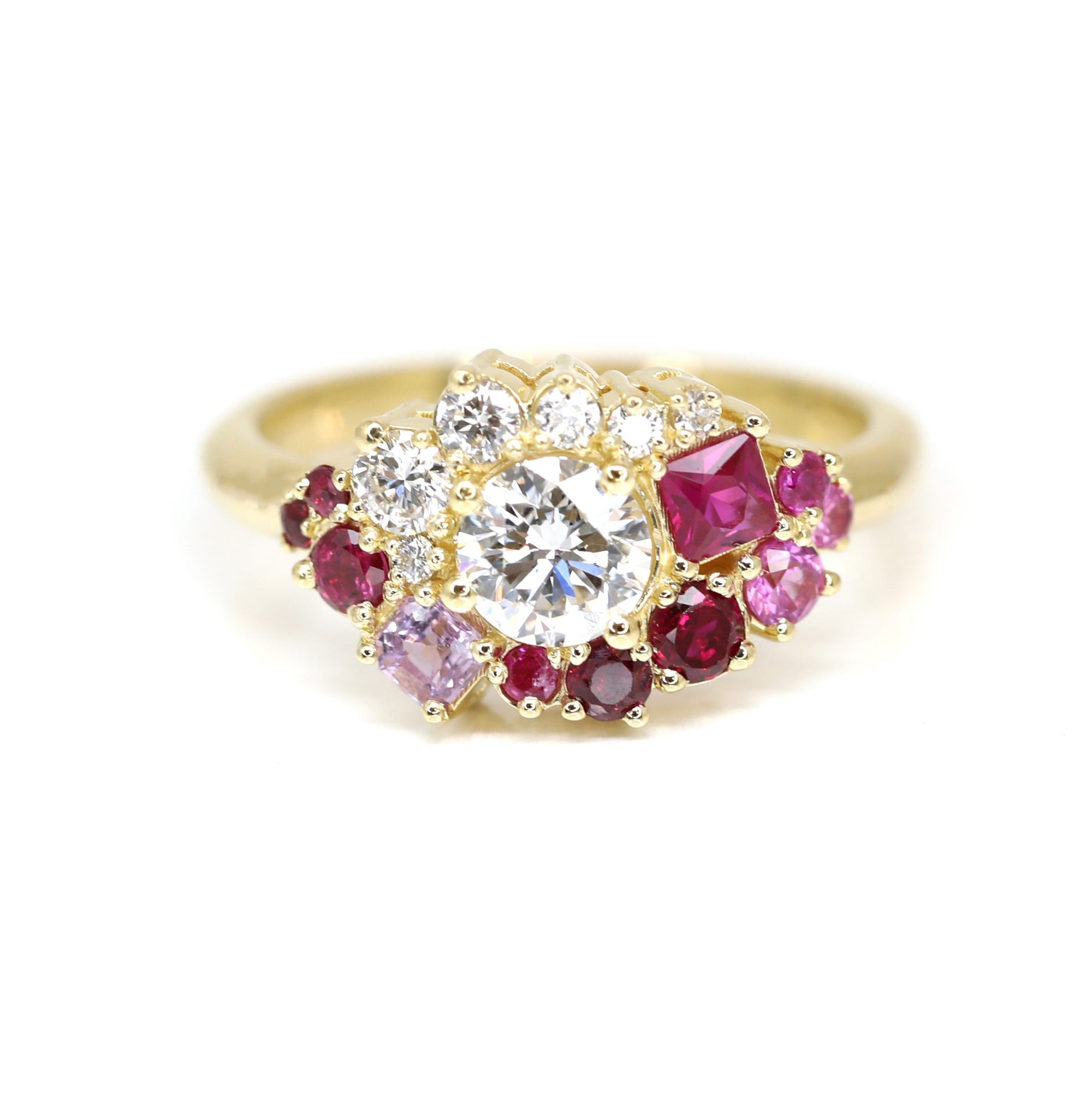 The Avalanche Ruby, Sapphire & Diamond Ring, highlighting its central diamond and striking rubies in polished yellow gold. Created by Bena Jewelry in Montreal, Canada.