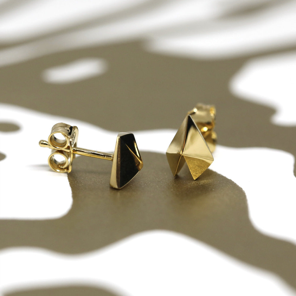 Yellow gold Edgy Gold Heart Studs by Bena Jewelry displayed on a black matte background contemporary designer earrings made in Canada