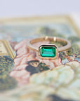 yellow gold emerald engagement ring custom made in montreal designer bena jewelry on multi color background