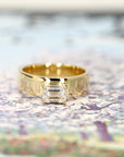 Modern yellow gold engagement ring with a bold emerald-cut diamond. Designed with a substantial gold band by Bena Jewelry, handcrafted in Montreal, Canada.
