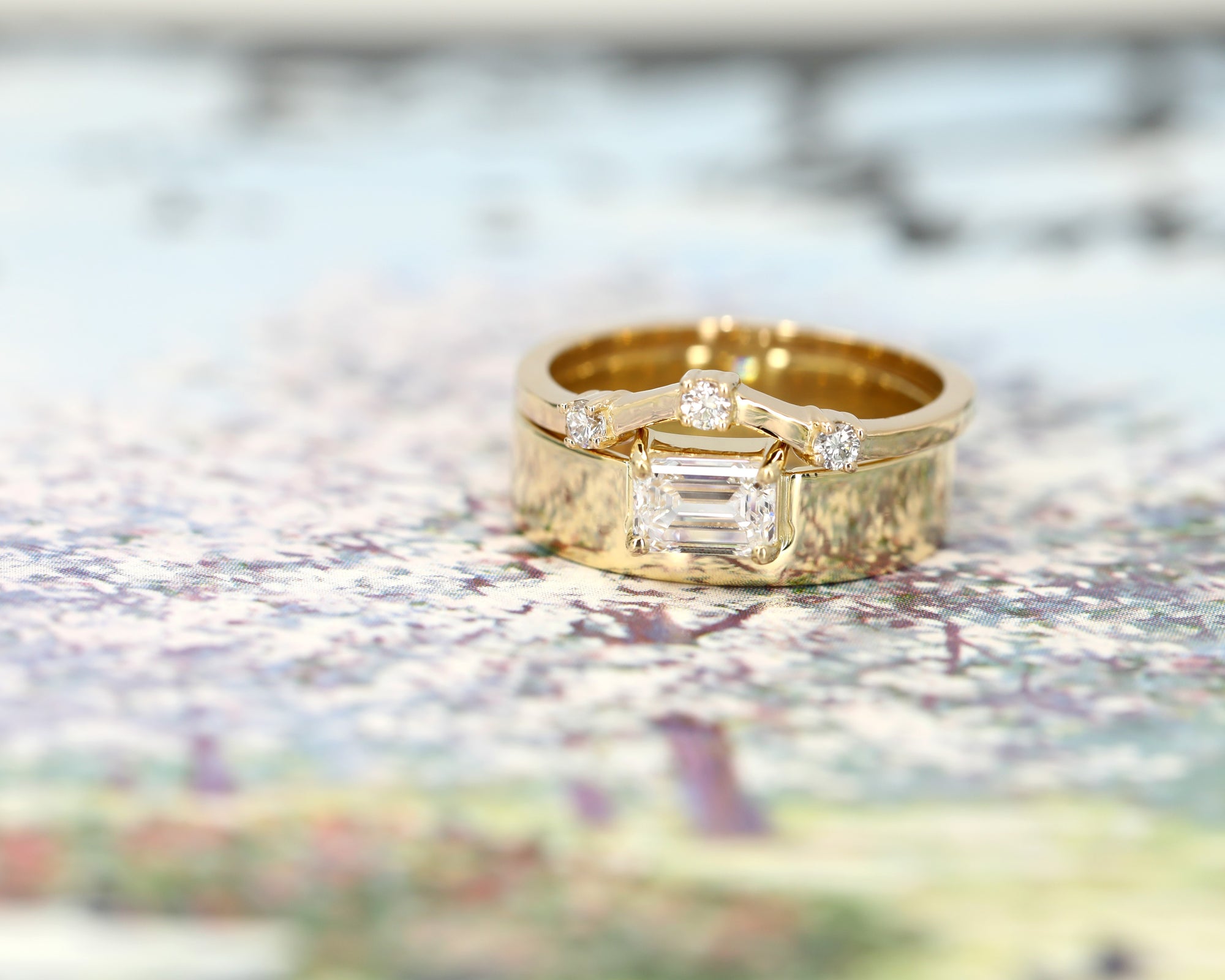 Modern yellow gold engagement ring with a prominent emerald-cut diamond and sleek, bold lines. Designed and made by Bena Jewelry, Montreal-based jewelry designer.