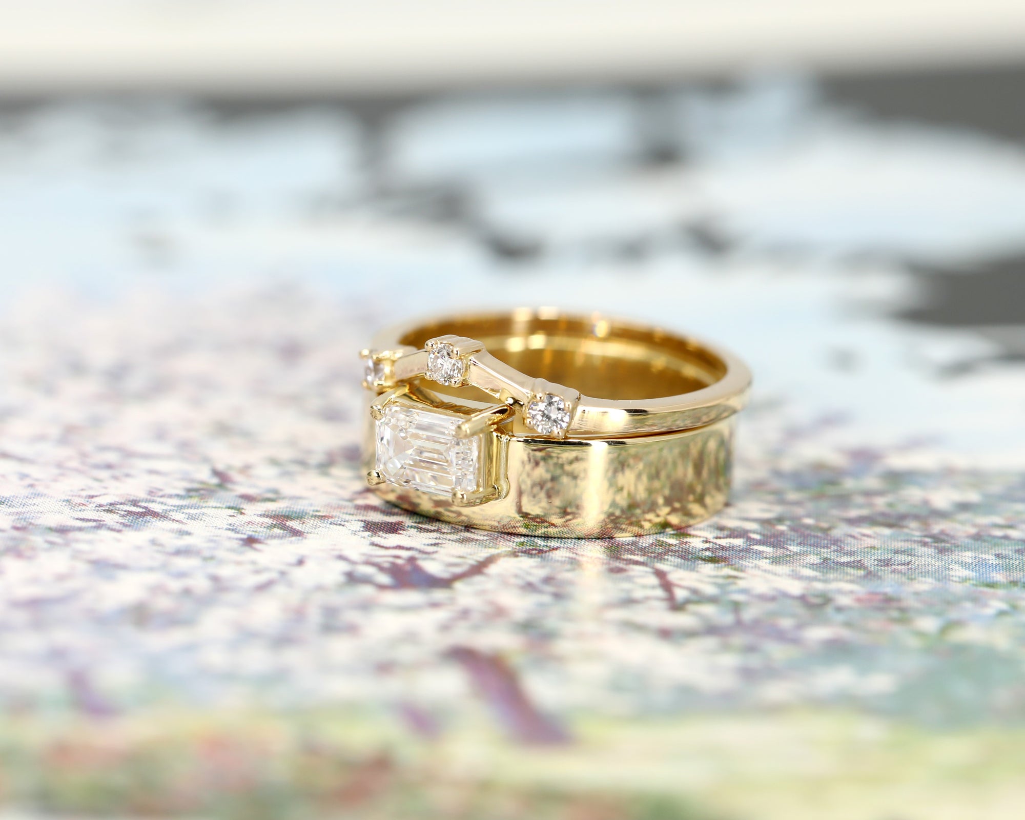 Wide yellow gold band with an emerald-cut diamond centerpiece. Contemporary and edgy fine jewelry by Bena Jewelry, crafted in Montreal, Canada.