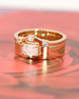 Yellow gold ring with a striking emerald-cut diamond and a wide gold band. A modern statement engagement ring by Bena Jewelry, Canadian designer.