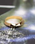 top view of gold ring for men with edgy style from the collection chiseled custom made bridal rings in montreal on dark multi color background