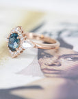 side view of diamond ring with oval shape montana sapphire custom made bridal ring with colored gemstone montreal by bena jewelry on multi color background