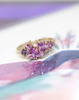 Highlights the interplay of pink and violet gemstones with the polished yellow gold band. Custom jewelry by Bena Jewelry, Montreal, Canada.