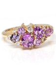 Front view: The Avalanche Pink Sapphire Ring showcasing its artistic arrangement of pink and violet sapphires with diamonds in a polished yellow gold setting. Designed by Bena Jewelry in Montreal, Canada.