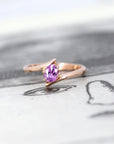front view of bena jewelry pink sapphire rose gold kink ring edgy engagement ring on balck and white background