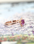 side view of rose gold twist engagement ring custom made in motnreal by bena jewelry on multi color background