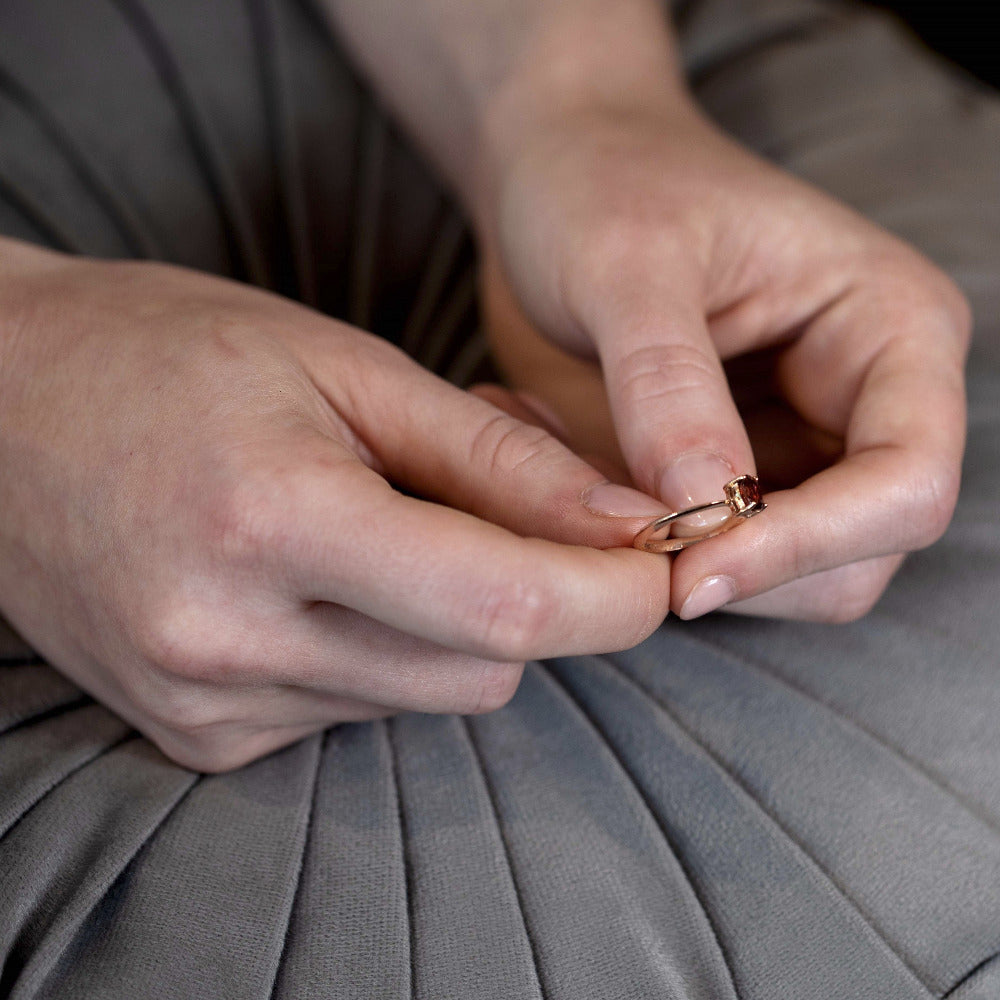 Detailed view of the Désir Pyrope Garnet Ring crafted in yellow gold with a pyrope garnet and diamonds worn on a woman’s hand fine jewelry by Bena Jewelry custom-made in Canada.