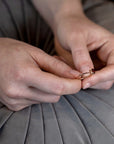 Detailed view of the Désir Pyrope Garnet Ring crafted in yellow gold with a pyrope garnet and diamonds worn on a woman’s hand fine jewelry by Bena Jewelry custom-made in Canada.