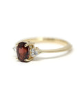 Side view of a yellow gold Désir Pyrope Garnet Ring by Bena Jewelry featuring a natural gemstone and diamonds photographed on a white background bespoke wedding jewelry