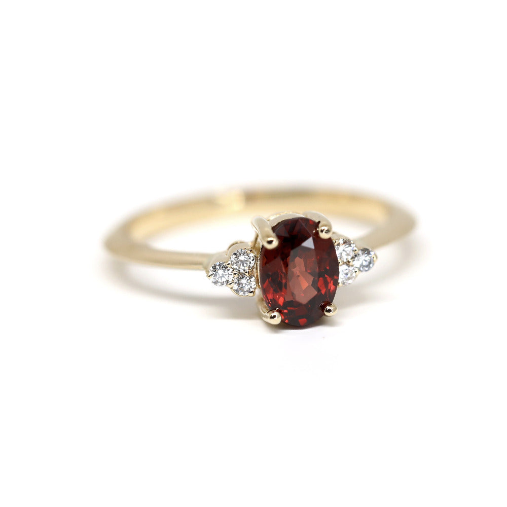 Désir Pyrope Garnet Ring in yellow gold featuring an oval pyrope garnet and side diamonds by Bena Jewelry photographed on a clean white background custom-made in Montreal