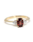 Désir Pyrope Garnet Ring in yellow gold featuring an oval pyrope garnet and side diamonds by Bena Jewelry photographed on a clean white background custom-made in Montreal