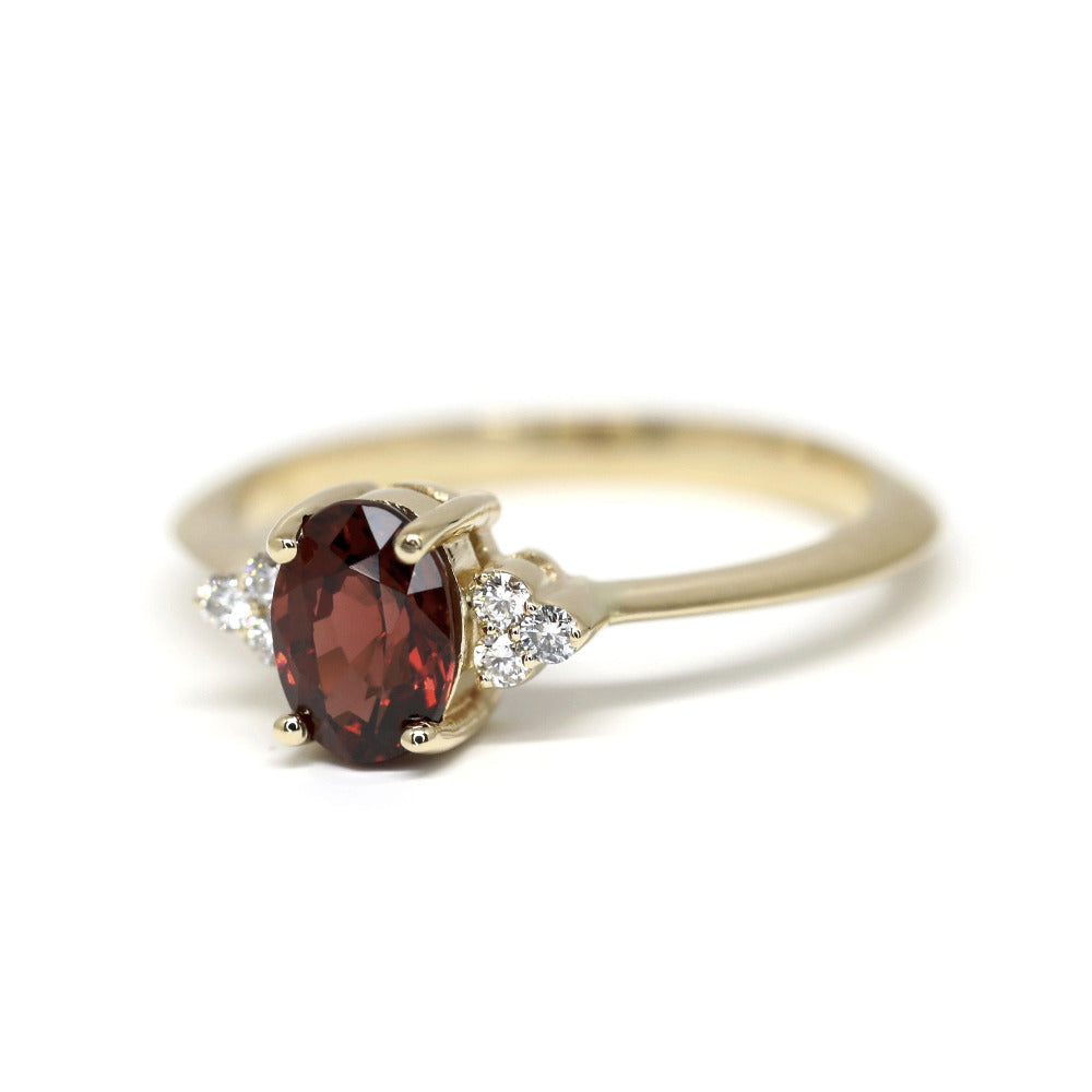 Classic yellow gold bridal ring with a vibrant pyrope garnet centerpiece and diamond accents by Bena Jewelry displayed on a white background fine jewelry made in Canada