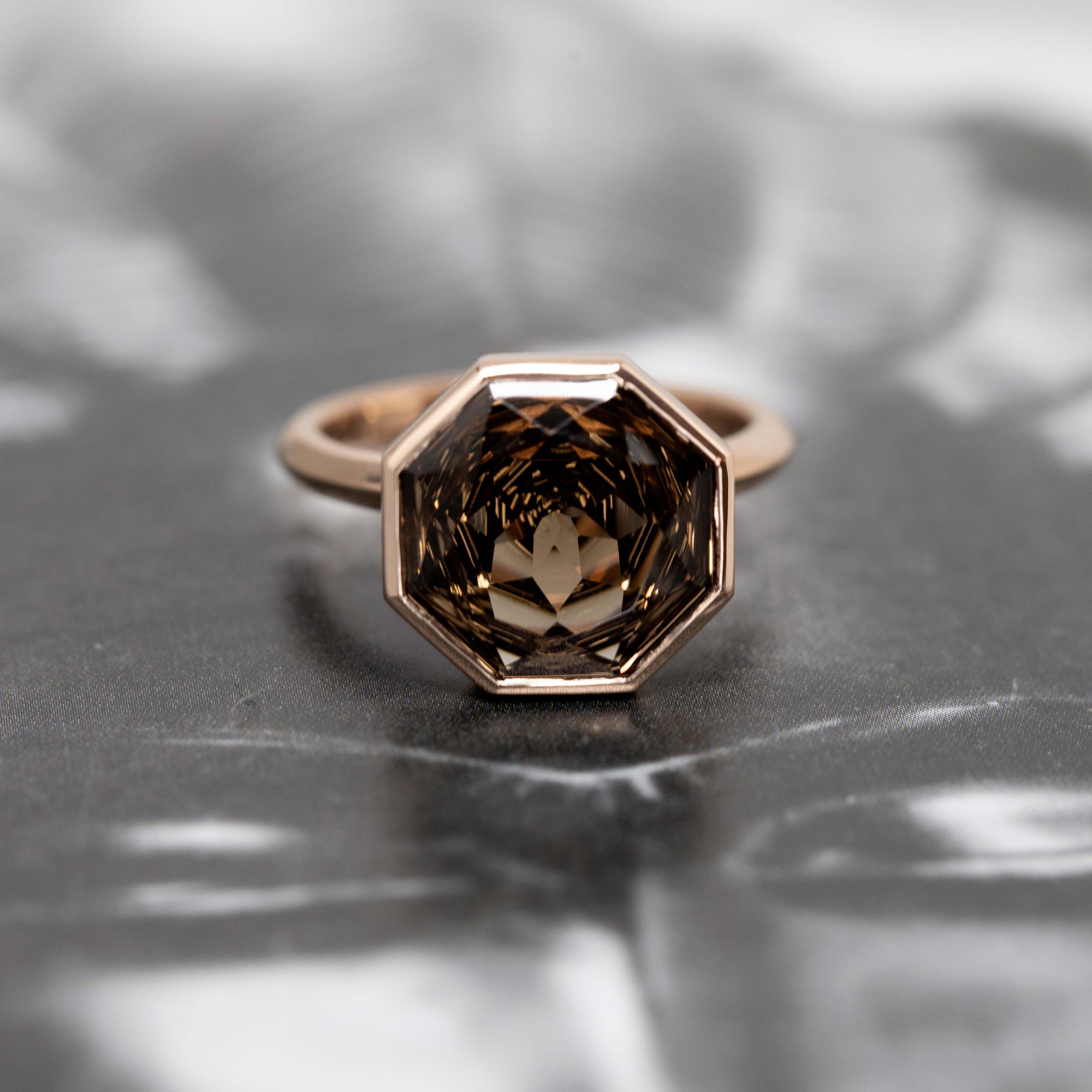 Bijou Round Octagon Smoky Ring with intricate gemstone faceting, handcrafted in Montreal by Bena Jewelry, displayed on a bold background.