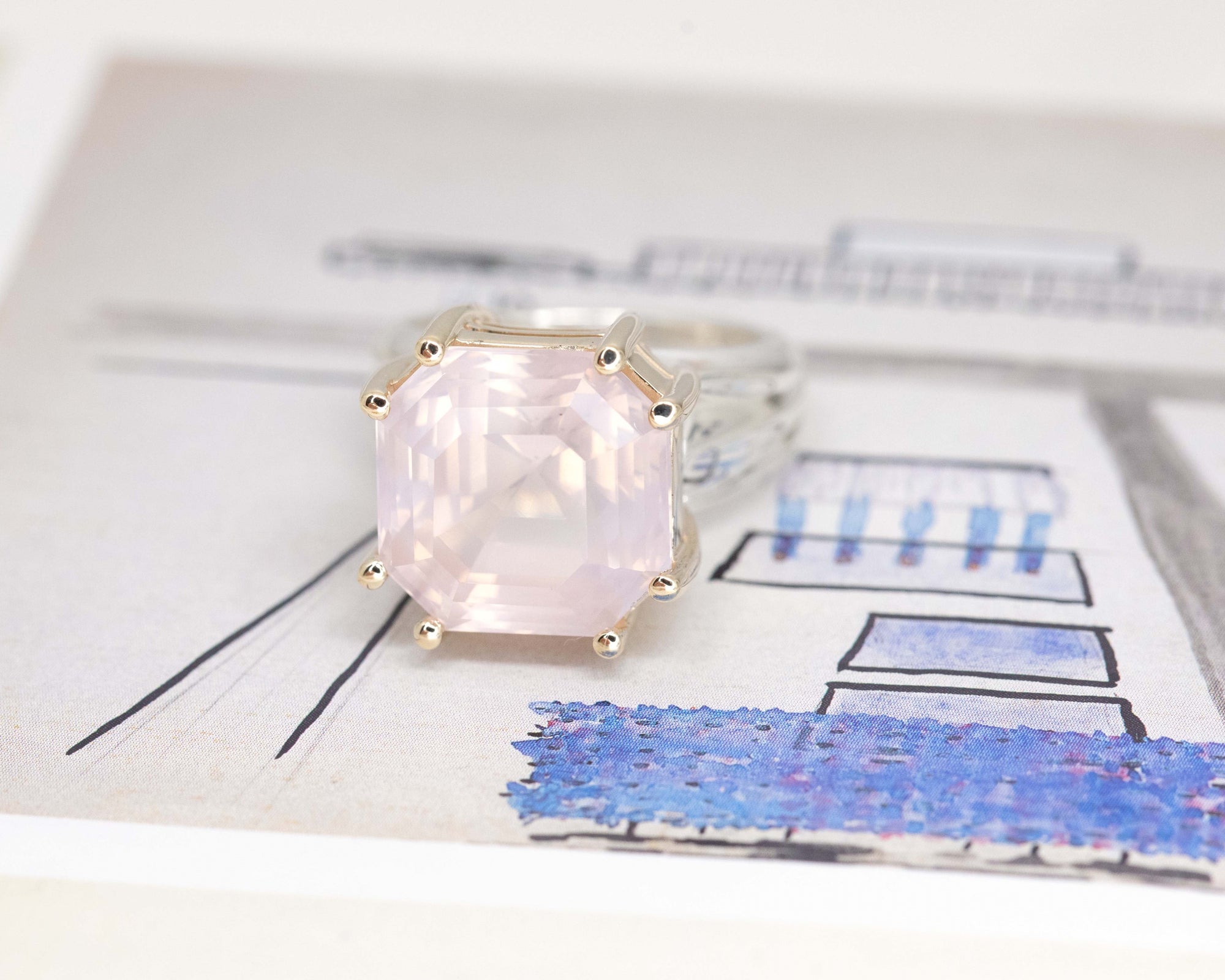 Top-down view of statement ring – A faceted, soft pink rose quartz gemstone, elegantly bezel-set in a mix of sterling silver and yellow gold.