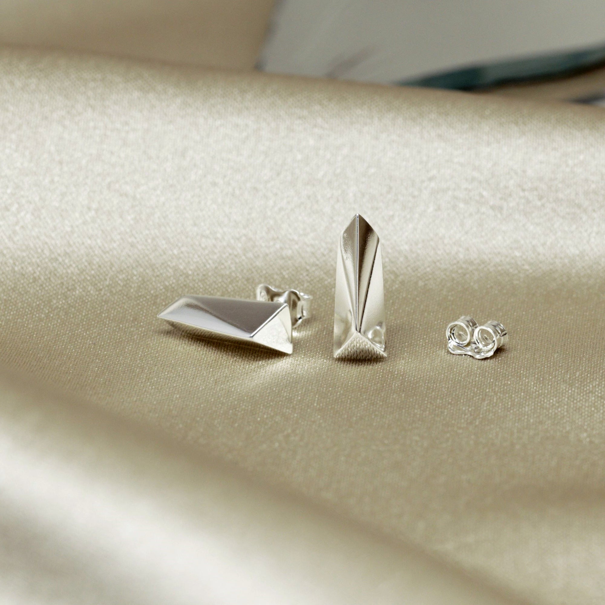 White Gold Pike Earrings on soft-toned background – The clean lines of these white gold earrings stand out beautifully against a neutral backdrop.