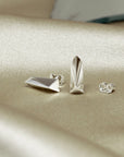 White Gold Pike Earrings on soft-toned background – The clean lines of these white gold earrings stand out beautifully against a neutral backdrop.