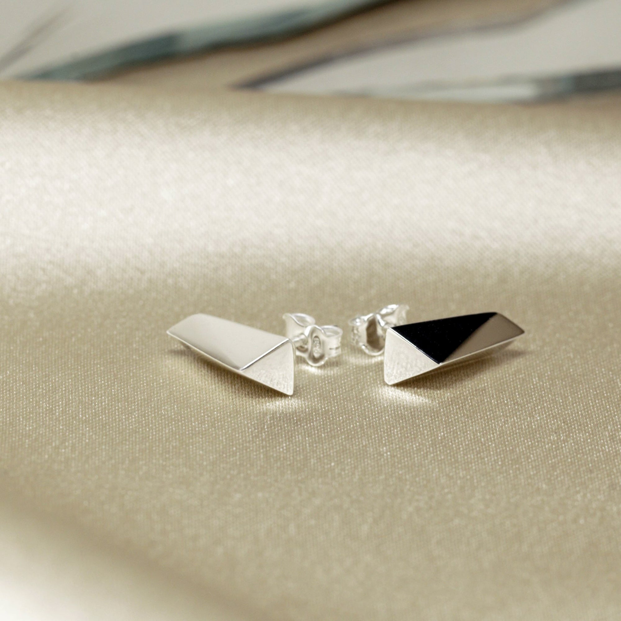 Close-up of White Gold Pike Earrings on dark background – The polished gold finish catches the light, emphasizing the sleek, contemporary design.