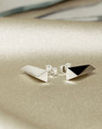 Close-up of White Gold Pike Earrings on dark background – The polished gold finish catches the light, emphasizing the sleek, contemporary design.