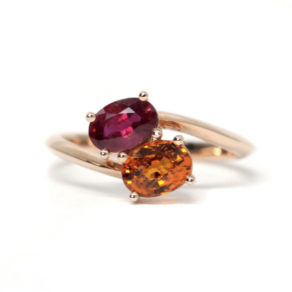 Toi et Moi Ruby & Spessartite Ring on white background – A unique engagement ring featuring a natural ruby and a spessartite garnet in rose gold. Handmade by Bena Jewelry in Montreal.