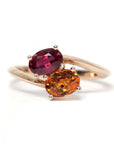 Toi et Moi Ruby & Spessartite Ring on white background – A unique engagement ring featuring a natural ruby and a spessartite garnet in rose gold. Handmade by Bena Jewelry in Montreal.