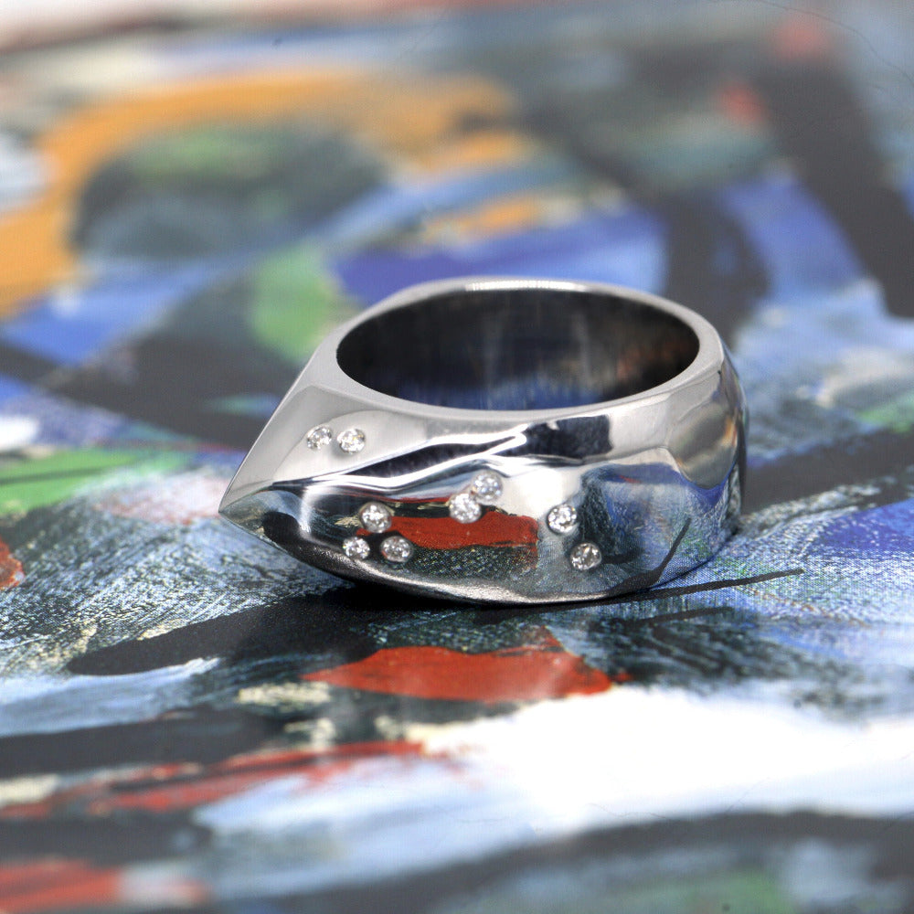 Alp Ring on soft-toned background – The silver and diamonds contrast beautifully against the subtle background.