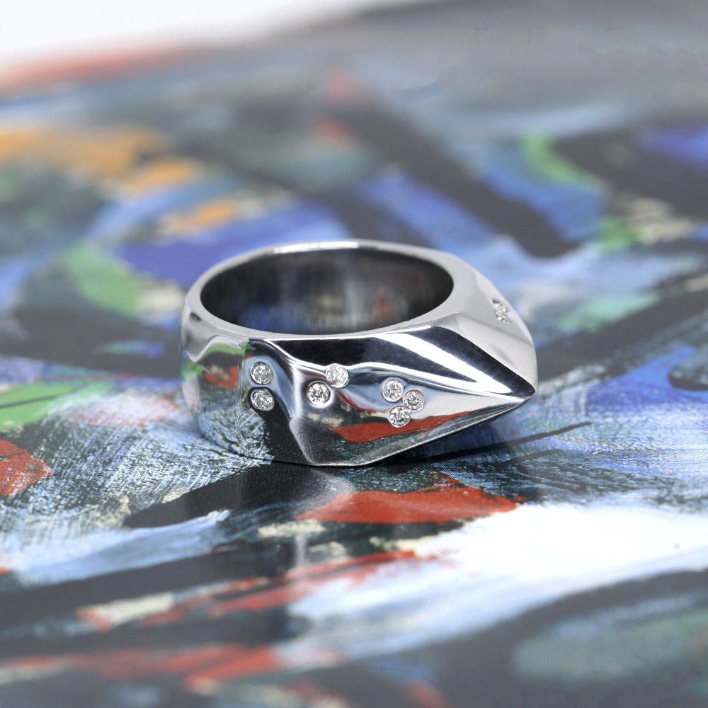 Close-up of silver ring on dark background – The raw texture and scattered diamonds create a striking, modern look.