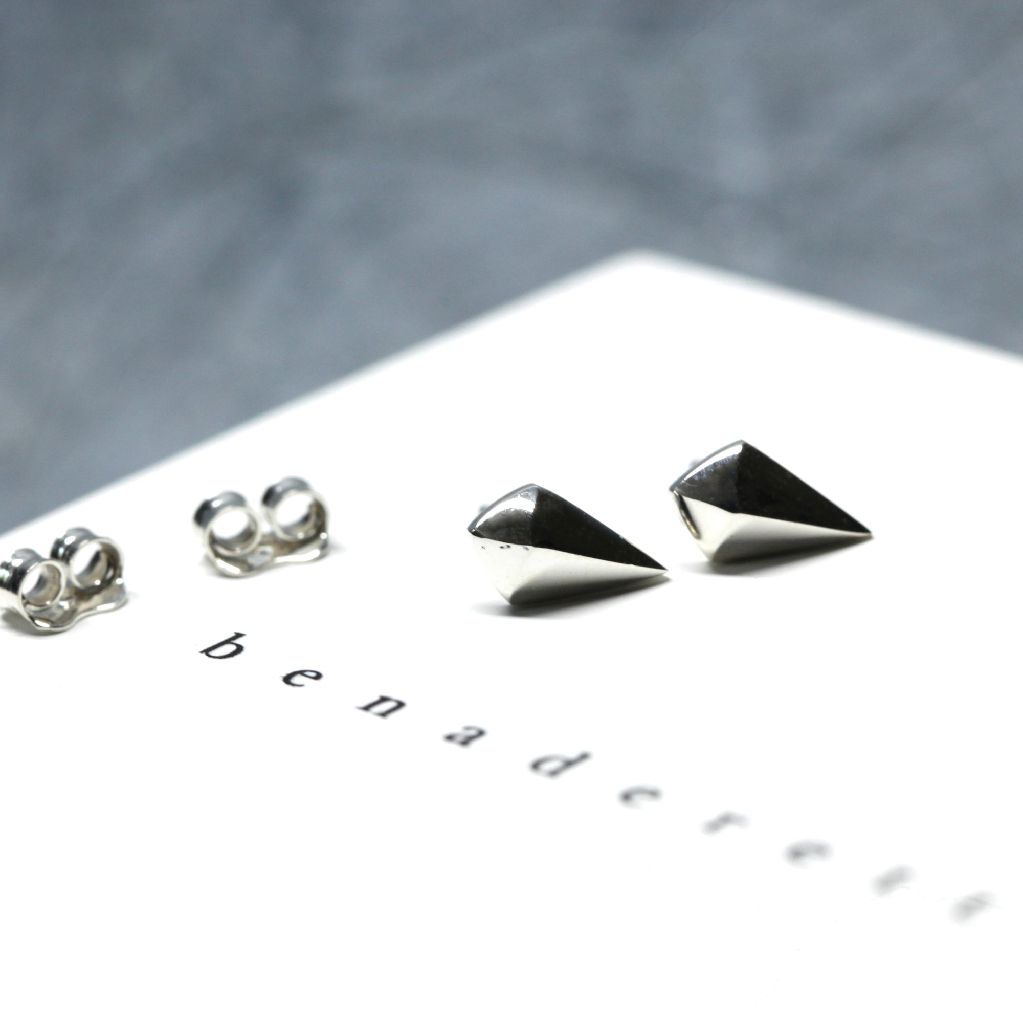 Mini Spade Gold Stud Earrings worn on ear, close-up – Small and modern, these discreet white gold studs add a refined touch to any look. Designed by Bena Jewelry in Montreal.