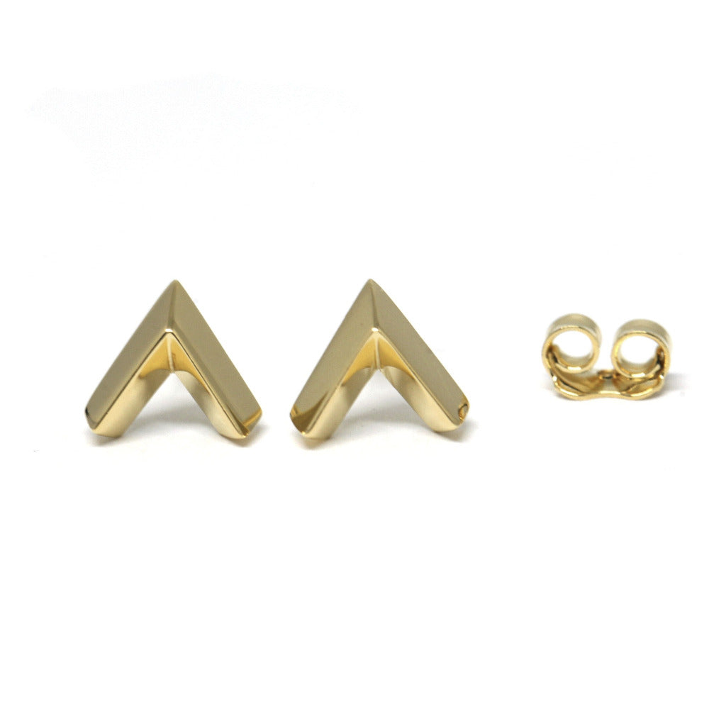 Close-up of a yellow gold arrow-shaped stud on a white background, minimalist, unisex, edgy, and bold design made in Montreal by Bena Jewelry, a Canadian fine jewelry designer.