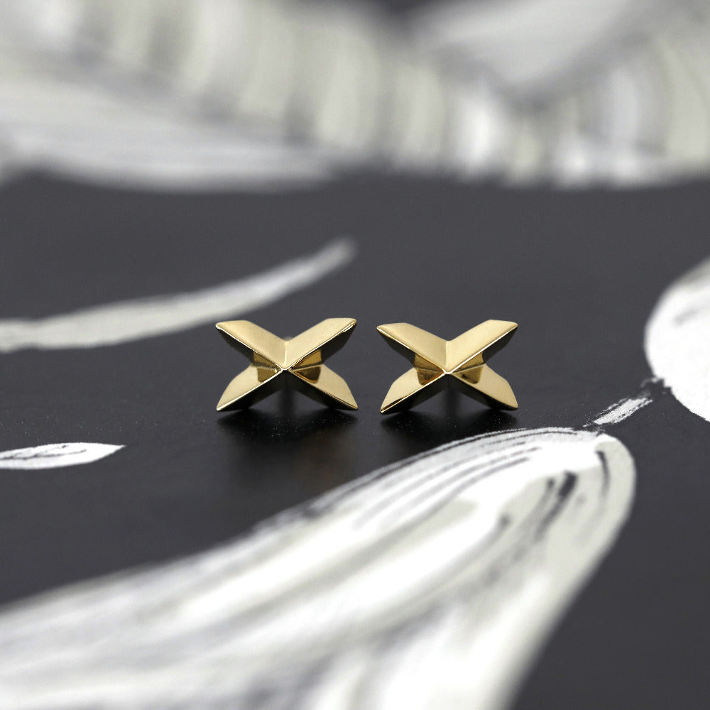 Yellow gold Cross Gold Studs with edgy sharp style by Bena Jewelry, displayed on a black matte background, fine designer earrings from Canada.