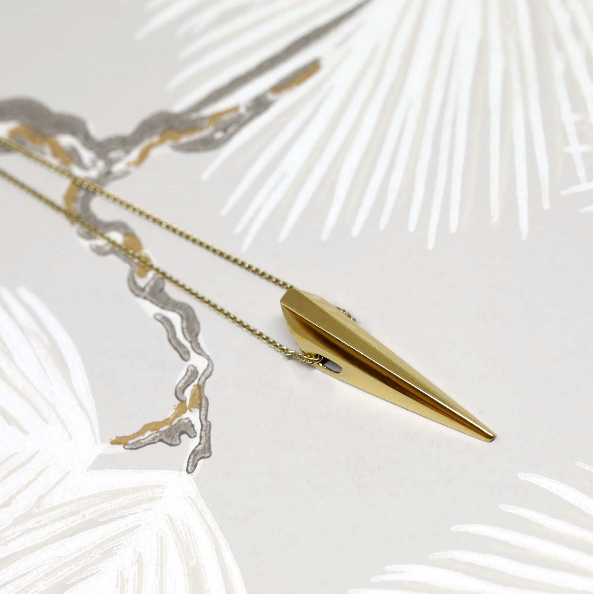Pike Pendant photographed in soft lighting – A designer gold pendant blending minimalism with bold elegance.