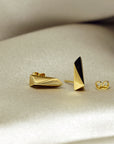 Close-up of gold earrings on dark background – Striking statement earrings in gold with a refined, contemporary aesthetic. A unique creation by Bena Jewelry, Montreal.