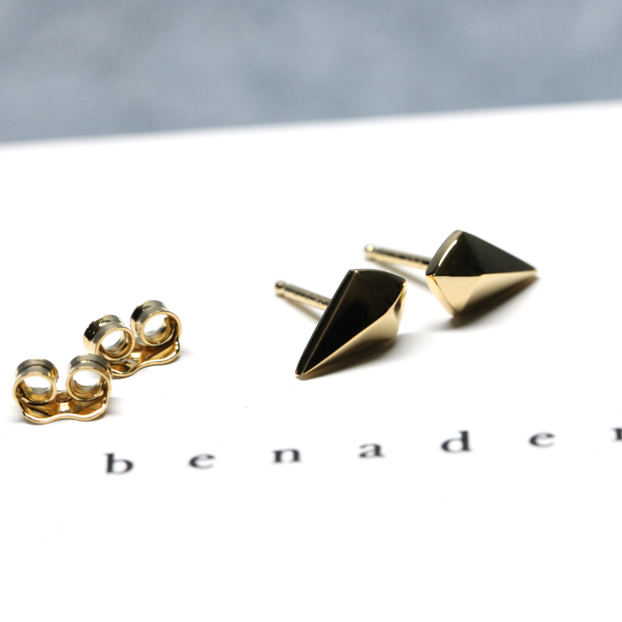 Angled shot of Mini Spade Studs – Unisex and subtle, these gold earrings offer effortless sophistication for any occasion.